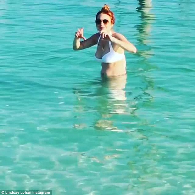 Lindsay Lohan flashes her cleavage in white Bikini as she braves the freezing cold sea during her winter break in Abu Dhabi
