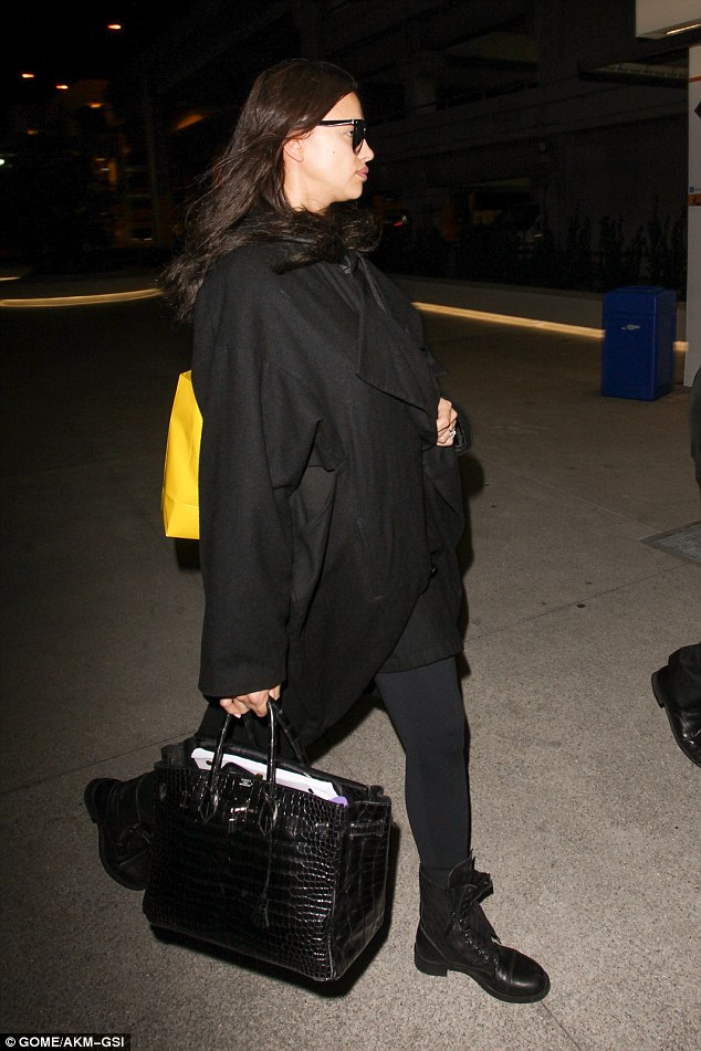 ‘Pregnant’ Irina Shayk places a protective hand on her belly as she wraps up for a flight out of LA