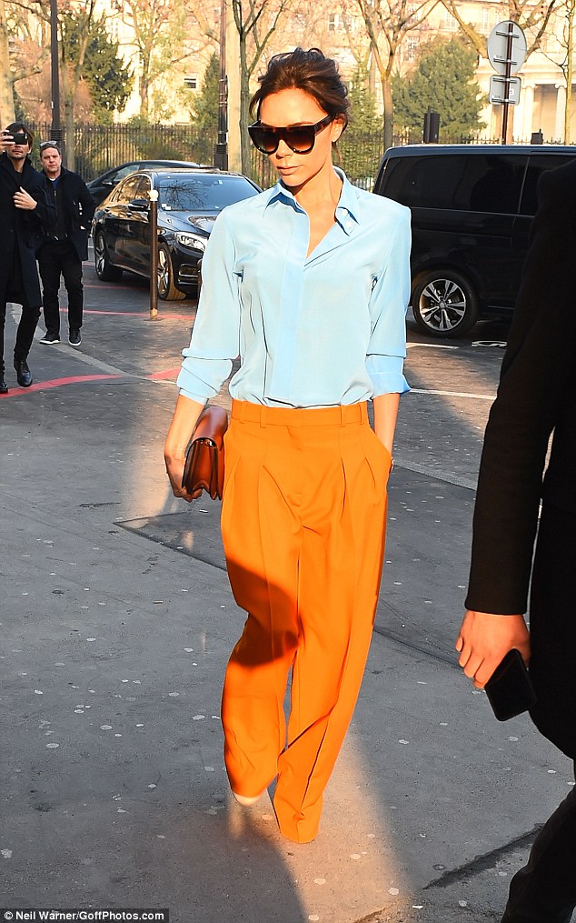 Victoria Beckham oozes glamour in billowing tangerine Trousers and a crisp Blue Blouse as she attends Paris Haute Couture Fashion Week